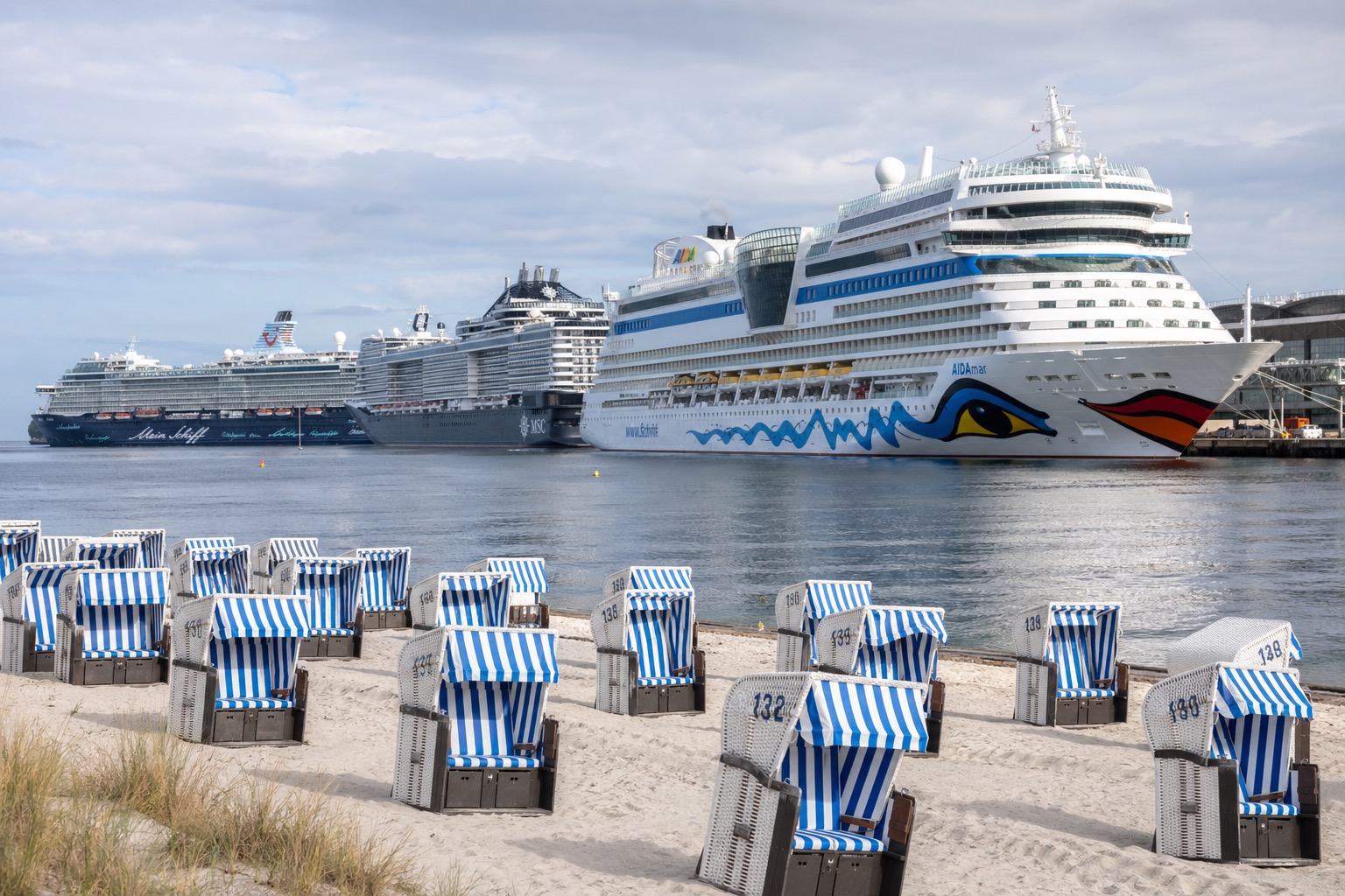 Warnemünde Strandkörbe vor AIDA und Mein Schiff Kreuzfahrtschiffen an der Ostsee.