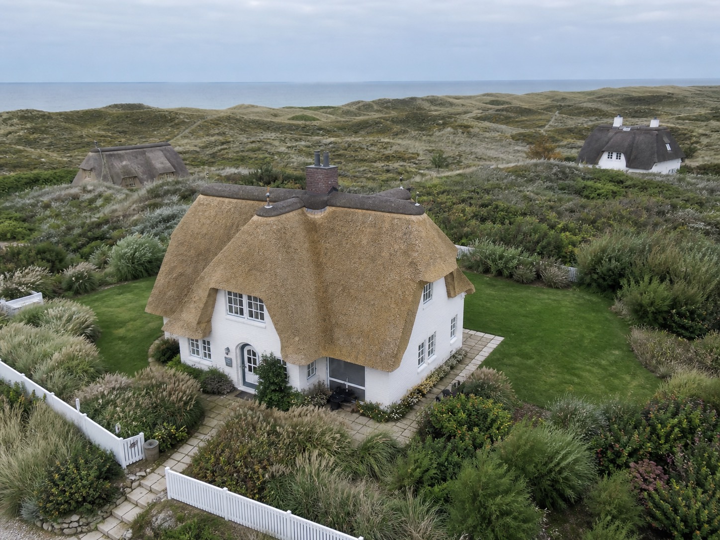 Luftaufnahme eines reetgedeckten Ferienhauses auf Sylt. Favorent unterstützt bei der Vermietung und Instandhaltung.